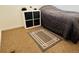 Neutral bedroom with a bed, cubical storage unit, and a geometric area rug on the carpeted floor at 500 30Th St # 5, Denver, CO 80205