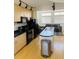 Modern kitchen with black appliances, light wood cabinetry, and an island with a stainless steel sink at 500 30Th St # 5, Denver, CO 80205