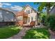 Backyard view of the house featuring a raised deck, patio, and landscaped yard with stone pathway at 2829 N Franklin St, Denver, CO 80205