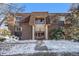 Charming exterior of a multi-Gathering building with brick accents, symmetrical design, and snow-covered landscape at 7755 E Quincy Ave # 301A2, Denver, CO 80237