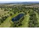 Picturesque aerial view of a golf course with lush fairways, a serene pond, and mature trees at 3860 S Elkhart St, Aurora, CO 80014