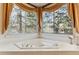 Bright bathroom featuring a large soaking tub with tiled surround and natural light at 3860 S Elkhart St, Aurora, CO 80014