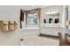 Bright bathroom with a double sink vanity, large mirror, and a soaking tub by the window at 3860 S Elkhart St, Aurora, CO 80014