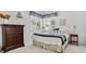 Cozy bedroom with a made bed between a window, nightstand, and a wooden dresser at 3860 S Elkhart St, Aurora, CO 80014