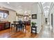 Dining room with hardwood floors, black table, and wine storage, open to the kitchen at 3860 S Elkhart St, Aurora, CO 80014