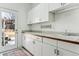 Well-lit laundry room with white cabinets, sink, and door to the outside at 3860 S Elkhart St, Aurora, CO 80014