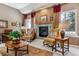 Comfortable living room with a fireplace, two chairs, and natural light from the windows at 3860 S Elkhart St, Aurora, CO 80014