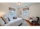 Bright bedroom featuring two windows, hardwood floors, a comfortable bed, and a decorative chair at 2836 Cherry St, Denver, CO 80207