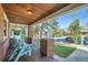 Inviting front porch featuring wood ceiling, brick pillars, and a cozy seating area at 2836 Cherry St, Denver, CO 80207