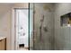 Modern bathroom shower featuring gray tile, glass door, and unique fixtures near Primary bedroom at 4264 Thorndyke Pl, Broomfield, CO 80020