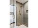 Modern bathroom shower featuring gray tile, glass door, and unique fixtures near Primary bedroom at 4264 Thorndyke Pl, Broomfield, CO 80020