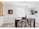 Cozy dining room featuring a black table with modern chairs, a window, and a floral painting at 4264 Thorndyke Pl, Broomfield, CO 80020