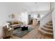Open-concept living area with modern decor, light-colored walls, and wood staircase at 4264 Thorndyke Pl, Broomfield, CO 80020