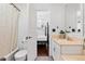 Bathroom with hardwood floors, a neutral-toned vanity, and a door looking into the connected bedroom at 449 S Humboldt St, Denver, CO 80209
