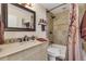 This bathroom shows a tiled shower, framed mirror, and vanity with white cabinets at 13635 E Bates Ave # 406, Aurora, CO 80014