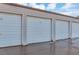 A row of enclosed garages in a storage facility or neighborhood with white doors and beige siding at 13635 E Bates Ave # 406, Aurora, CO 80014