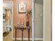 Hallway with neutral walls leading to the bathroom and a living space, featuring a decorative table and accents at 13635 E Bates Ave # 406, Aurora, CO 80014