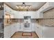 Bright kitchen with white cabinetry, granite countertops, tile backsplash, and modern appliances for a functional space at 13635 E Bates Ave # 406, Aurora, CO 80014