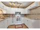 Charming kitchen with white cabinets, granite counters, and tile details, equipped with modern appliances for cooking at 13635 E Bates Ave # 406, Aurora, CO 80014