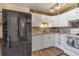 Bright kitchen features white cabinetry, granite countertops, and modern black stainless steel appliances at 13635 E Bates Ave # 406, Aurora, CO 80014