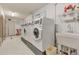 Clean laundry room featuring multiple washers, a utility sink, and ample lighting at 13635 E Bates Ave # 406, Aurora, CO 80014