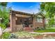 Charming brick home featuring a covered porch, red brick stairs, and lovely landscaped front yard at 840 S Corona St, Denver, CO 80209