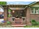 Inviting brick front porch with cozy seating and decorative planters at 840 S Corona St, Denver, CO 80209