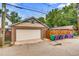Detached garage with a large white door, adjacent to a fenced yard and alleyway at 840 S Corona St, Denver, CO 80209