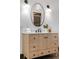 A bathroom vanity with marble countertop, oval mirror, and modern lighting sconces at 624 E 18Th Ave # 3, Denver, CO 80203
