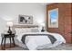Bright bedroom with white bedding, exposed brick, and stylish decor at 624 E 18Th Ave # 3, Denver, CO 80203