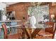 Bright dining area featuring a glass-top table, brick accent wall, and view into the adjacent living space at 624 E 18Th Ave # 3, Denver, CO 80203