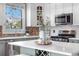 Bright kitchen with white cabinets, gray island, stainless steel appliances, and charming brick accents at 624 E 18Th Ave # 3, Denver, CO 80203