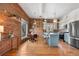 Open-concept kitchen featuring brick walls, an island, stainless steel appliances, and a dining area at 624 E 18Th Ave # 3, Denver, CO 80203