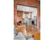 Open concept kitchen with an island, stainless steel appliances, brick accents, and hardwood floors at 624 E 18Th Ave # 3, Denver, CO 80203