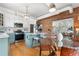 Open-concept kitchen and dining area featuring stainless steel appliances, exposed brick, white cabinetry and hardwood floors at 624 E 18Th Ave # 3, Denver, CO 80203