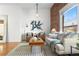 Inviting living room with brick accent wall, modern sofa, hardwood floors, and lots of natural light at 624 E 18Th Ave # 3, Denver, CO 80203
