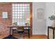 Office space featuring brick accent wall, wood floors, and a window with natural light at 624 E 18Th Ave # 3, Denver, CO 80203