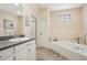 Bright bathroom features a tiled soaking tub, white vanity, and modern fixtures at 2601 S Kipling Ct, Lakewood, CO 80227