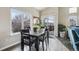 Cozy dining area with dark table, cushioned chairs, large windows, and sliding door access to the deck at 2601 S Kipling Ct, Lakewood, CO 80227