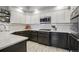 Modern kitchen featuring white upper cabinets, dark lower cabinets, and stainless steel microwave at 2601 S Kipling Ct, Lakewood, CO 80227