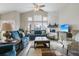 Cozy living room features large windows, a stone fireplace, hardwood floors, and comfortable seating at 2601 S Kipling Ct, Lakewood, CO 80227