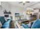 Bright living room with stone fireplace, ceiling fan, wood floors, and comfortable blue furniture at 2601 S Kipling Ct, Lakewood, CO 80227