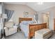 Comfortable main bedroom with a wood frame bed, soft blue accents, and a cozy sitting area at 2601 S Kipling Ct, Lakewood, CO 80227