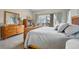 Serene main bedroom with a wood frame bed, dresser, and sliding glass door to the deck at 2601 S Kipling Ct, Lakewood, CO 80227