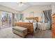 Bright main bedroom featuring a wood frame bed, large windows, and access to an outdoor deck at 2601 S Kipling Ct, Lakewood, CO 80227