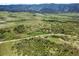 Panoramic view of rolling green hills, with homes nestled among the trees and a road winding through the landscape at 8821 S Perry Park Rd, Larkspur, CO 80118