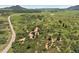 Expansive aerial view of a property surrounded by lush greenery and winding roads at 8821 S Perry Park Rd, Larkspur, CO 80118