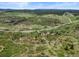 Scenic aerial view featuring a vast landscape with rolling hills and scattered greenery under a blue sky at 8821 S Perry Park Rd, Larkspur, CO 80118
