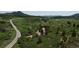 Picturesque landscape of rolling hills and green pastures, dotted with homes and a winding road in the distance at 8821 S Perry Park Rd, Larkspur, CO 80118