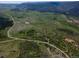 An aerial view of the property featuring rolling green hills and a distant mountain range at 8821 S Perry Park Rd, Larkspur, CO 80118